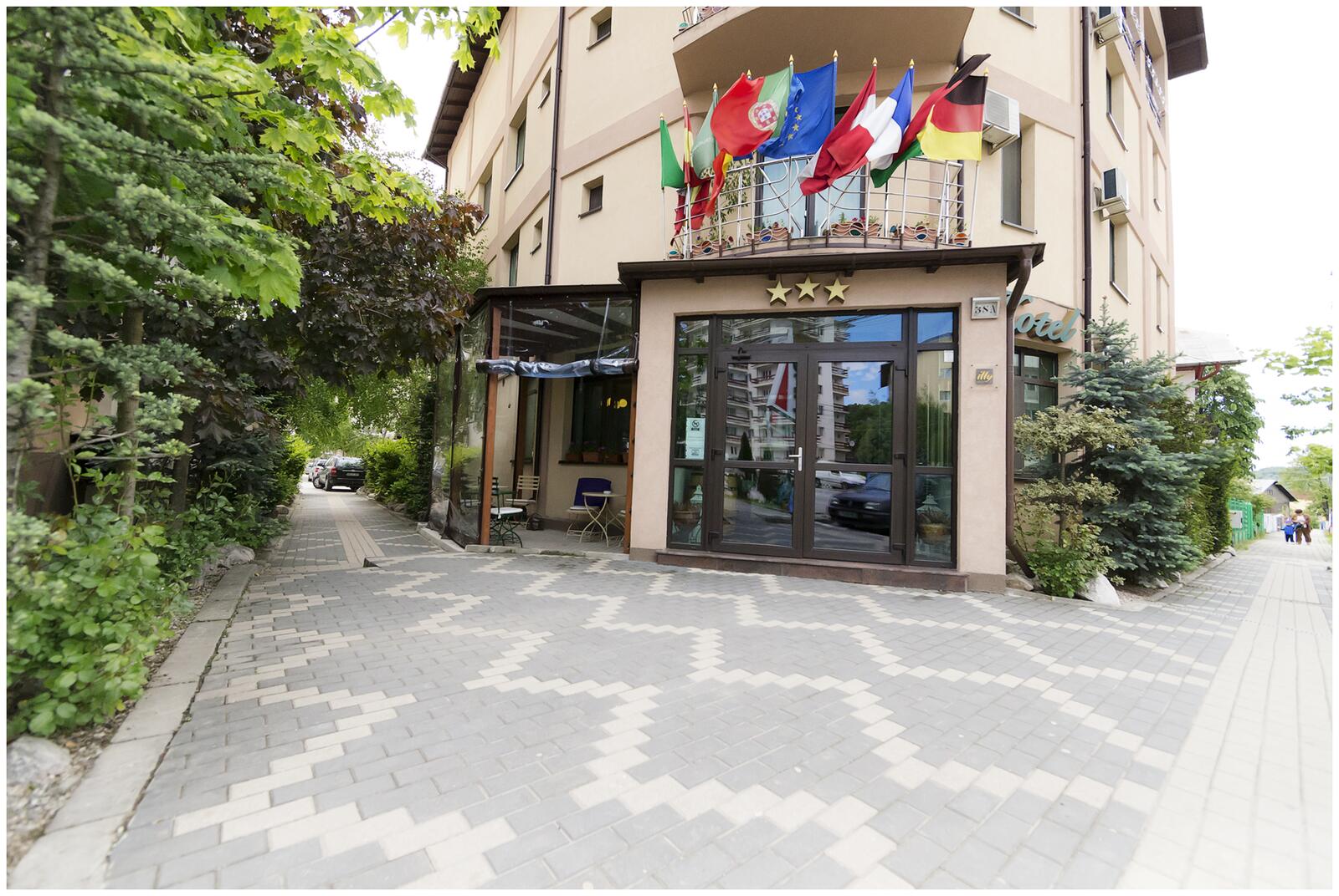 Intrarea în Hotel Vio din Fieni, cu steaguri la balcon